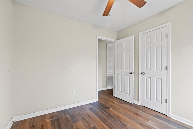 unfurnished bedroom featuring a ceiling fan, wood finished floors, visible vents, and baseboards