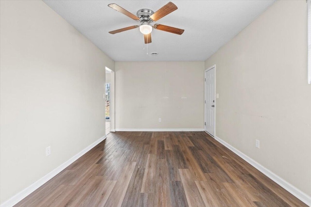 unfurnished room featuring wood finished floors, a ceiling fan, and baseboards