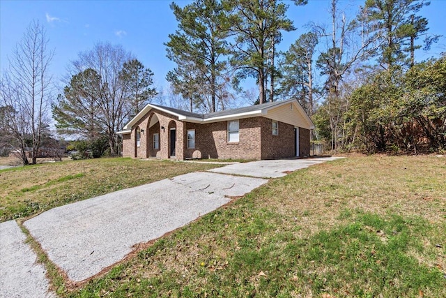 view of front of home featuring concrete driveway, a front lawn, and brick siding