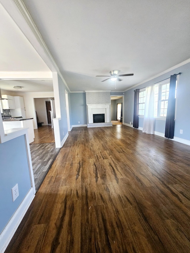 4596 Hickory Dr, Evans, GA 30809 - unfurnished living room featuring a ceiling fan, dark wood-style floors, baseboards, a fireplace with raised hearth, and crown molding