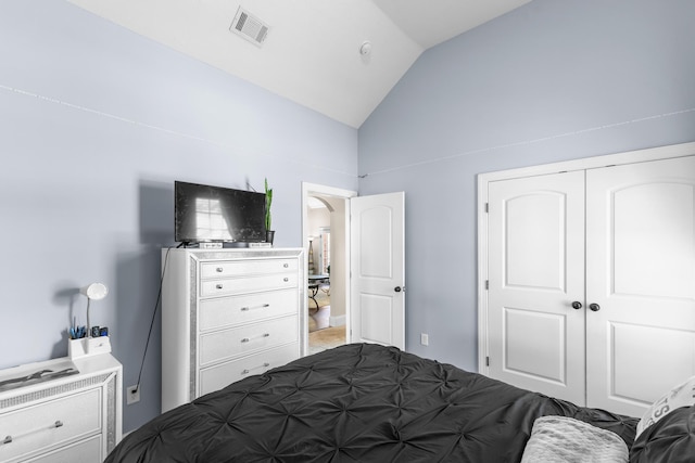 bedroom with vaulted ceiling and a closet