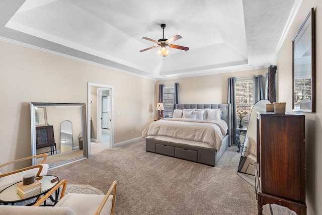 carpeted bedroom featuring crown molding, a raised ceiling, and ceiling fan