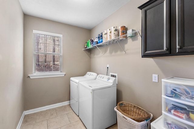 laundry room with light tile patterned floors, washing machine and dryer, and cabinets