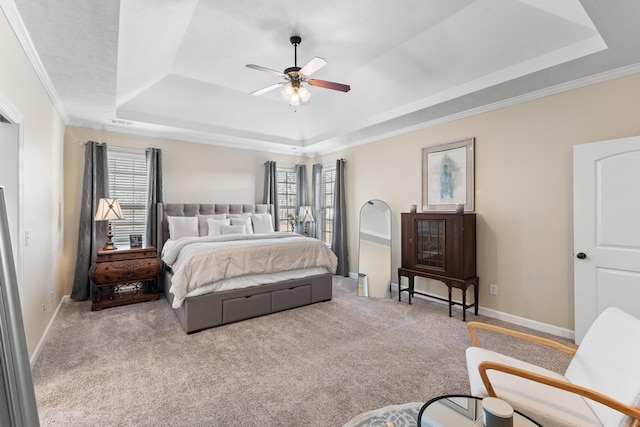 bedroom with multiple windows, carpet flooring, ceiling fan, and a tray ceiling