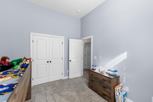 carpeted bedroom featuring a towering ceiling and a closet