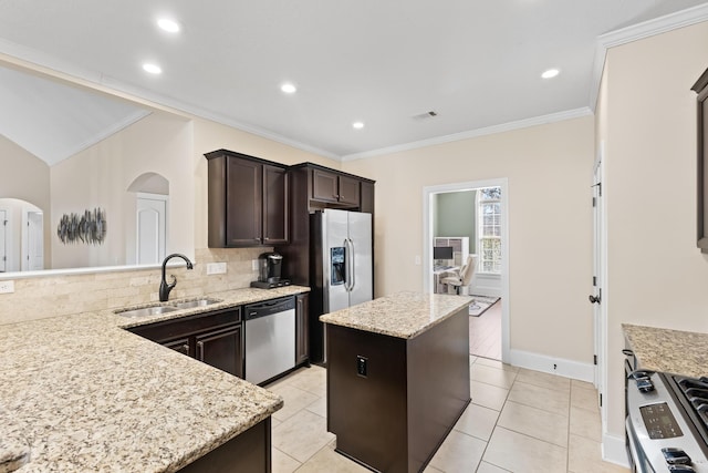 kitchen with sink, light tile patterned floors, appliances with stainless steel finishes, a center island, and light stone counters