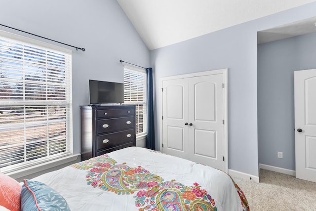 bedroom with lofted ceiling, carpet floors, and a closet