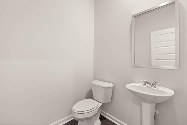 3447 Firestone Dr, Hephzibah, GA 30815 - half bathroom with wood finished floors, baseboards, a sink, and toilet
