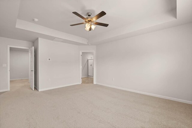 3447 Firestone Dr, Hephzibah, GA 30815 - unfurnished bedroom with ceiling fan, baseboards, a tray ceiling, and light carpet