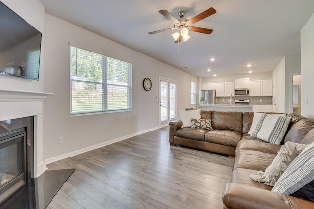 6093 Whitewater Dr, North Augusta, SC 29841 - living area with a ceiling fan, wood finished floors, a glass covered fireplace, baseboards, and recessed lighting