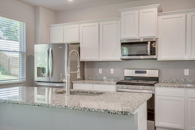 6093 Whitewater Dr, North Augusta, SC 29841 - kitchen with stainless steel appliances, white cabinets, a sink, and light stone countertops