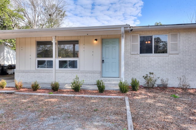 doorway to property featuring brick siding and crawl space