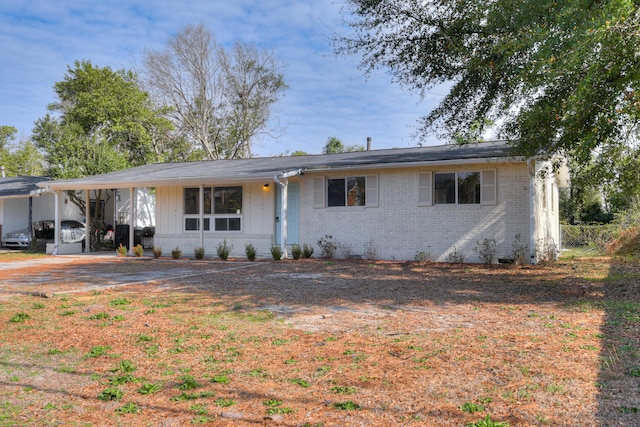 ranch-style home featuring brick siding and an attached carport