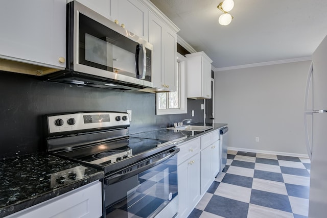 kitchen featuring light floors, ornamental molding, stainless steel appliances, white cabinetry, and a sink