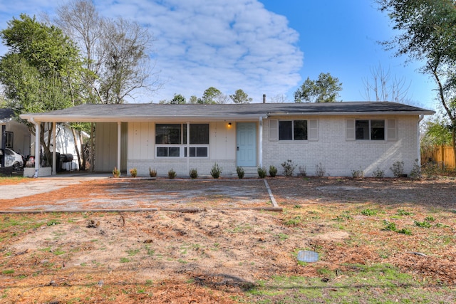 ranch-style house featuring board and batten siding, a carport, and brick siding