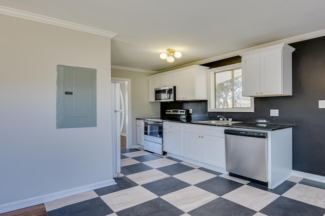 kitchen featuring dark countertops, crown molding, light floors, electric panel, and appliances with stainless steel finishes