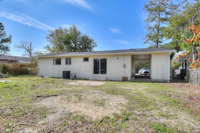 back of property with cooling unit, a lawn, brick siding, and fence