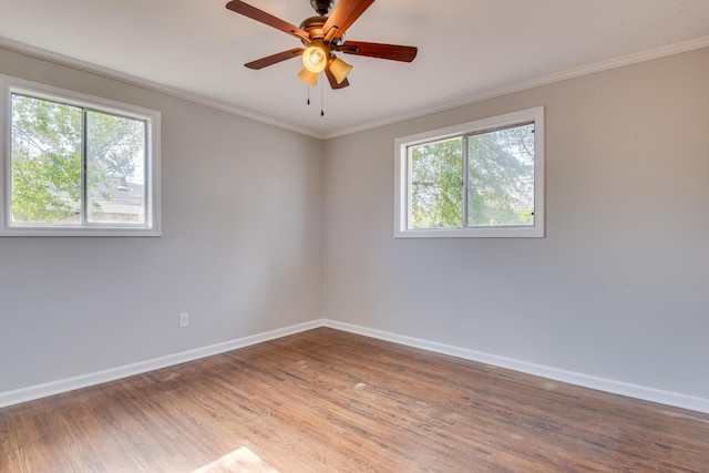 unfurnished room with baseboards, a healthy amount of sunlight, wood finished floors, and crown molding