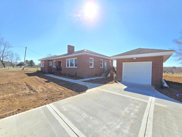 ranch-style house featuring an outbuilding, brick siding, a chimney, crawl space, and driveway