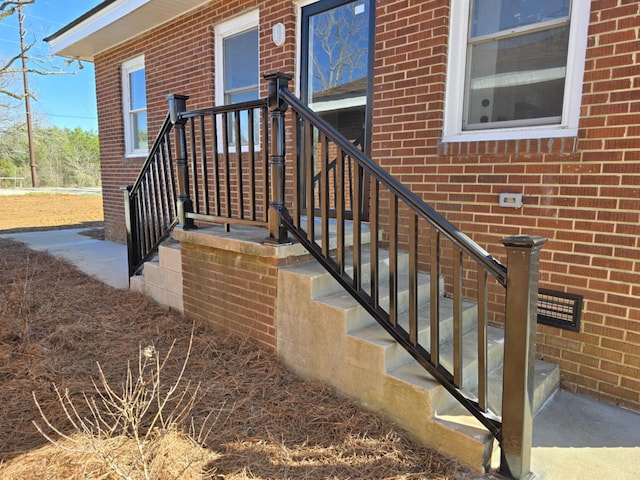 view of exterior entry featuring brick siding