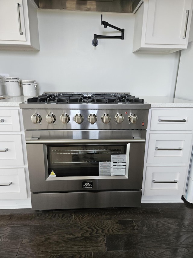 details with range hood, high end range, and white cabinets