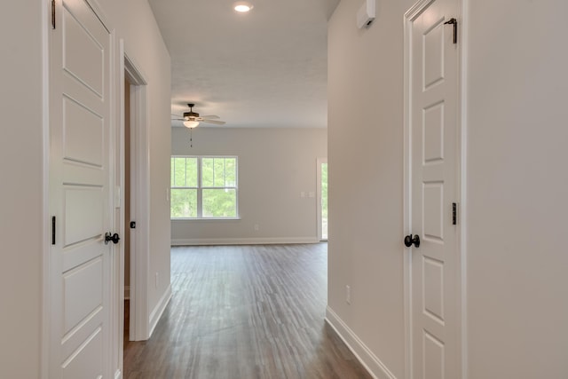 hallway with recessed lighting, baseboards, and dark wood finished floors