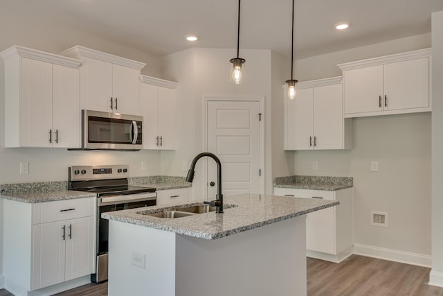 kitchen with a center island with sink, white cabinetry, stainless steel appliances, and a sink