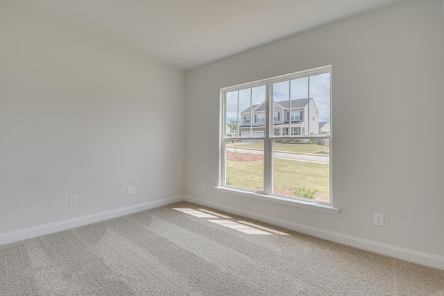 carpeted spare room featuring baseboards