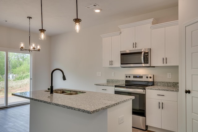 kitchen with visible vents, a center island with sink, a sink, stainless steel appliances, and light stone countertops