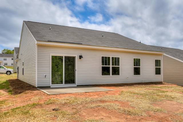 rear view of house with a patio and roof with shingles