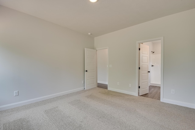 unfurnished room featuring carpet and baseboards