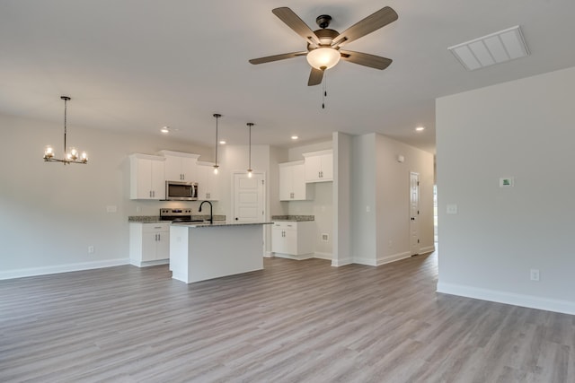 kitchen with visible vents, baseboards, open floor plan, appliances with stainless steel finishes, and a kitchen island with sink