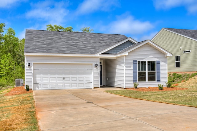 ranch-style home with cooling unit, an attached garage, driveway, and a front yard