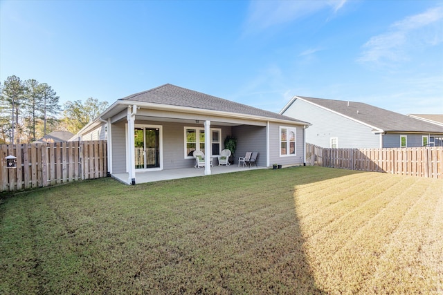 rear view of house featuring a yard and a patio