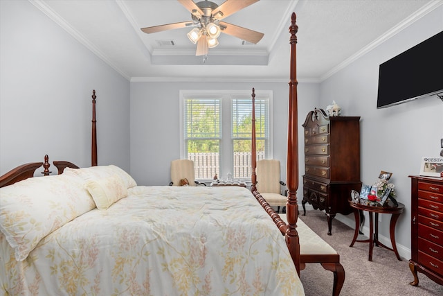 carpeted bedroom with a tray ceiling, ceiling fan, and crown molding