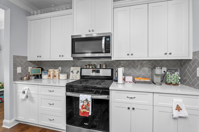 kitchen featuring backsplash, crown molding, dark hardwood / wood-style floors, white cabinetry, and stainless steel appliances