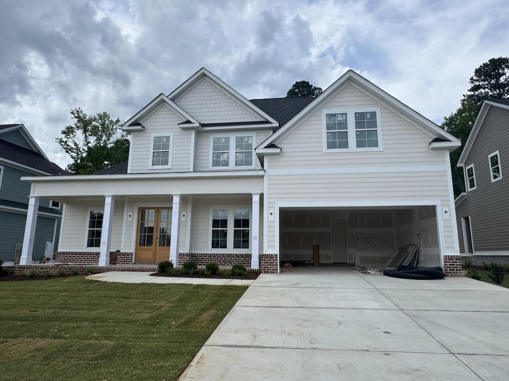 640 River Oaks Ln, Evans, GA 30809 - view of front facade with brick siding, covered porch, concrete driveway, french doors, and a front lawn