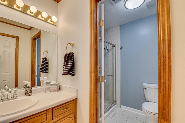 bathroom with toilet, vanity, a stall shower, tile patterned flooring, and baseboards