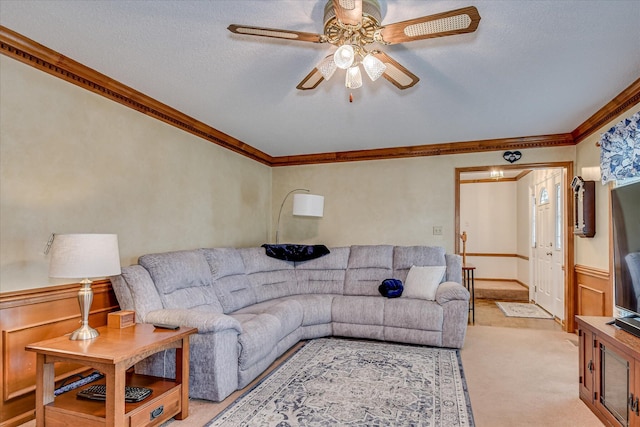 living area featuring ceiling fan, light carpet, and ornamental molding