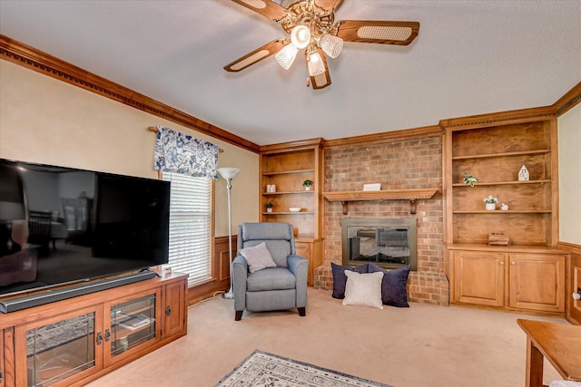 living room featuring light colored carpet, crown molding, ceiling fan, and built in shelves