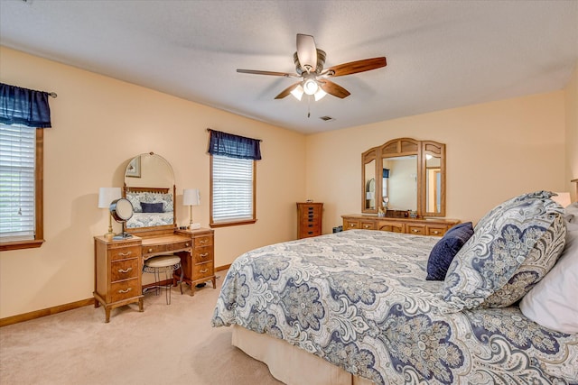 bedroom featuring light colored carpet, visible vents, baseboards, and a ceiling fan