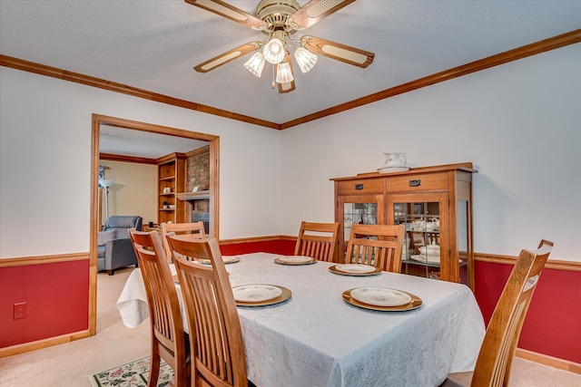 dining area featuring carpet, baseboards, a ceiling fan, and ornamental molding