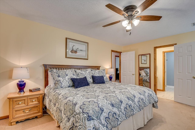 bedroom with light colored carpet, visible vents, baseboards, and ceiling fan