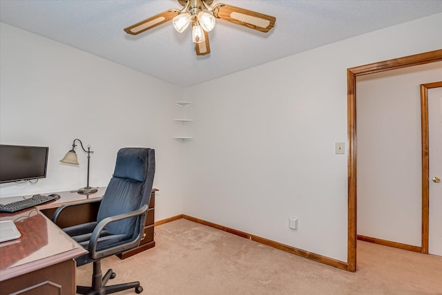 office space with baseboards, light carpet, and ceiling fan