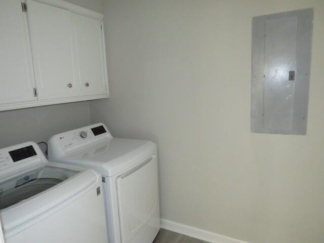 laundry area featuring separate washer and dryer, wood finished floors, baseboards, cabinet space, and electric panel