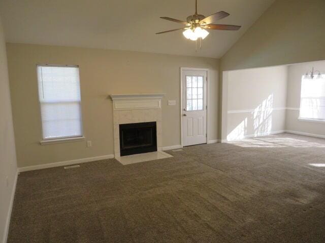 unfurnished living room featuring vaulted ceiling, dark colored carpet, a fireplace, and baseboards