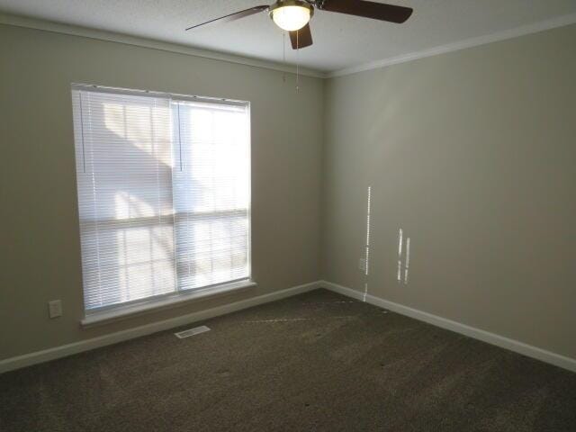 unfurnished room with dark colored carpet, plenty of natural light, and baseboards