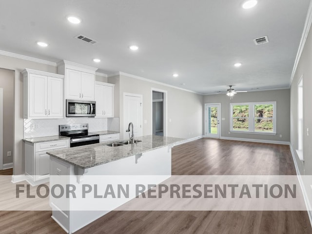 kitchen featuring an island with sink, appliances with stainless steel finishes, sink, and white cabinets