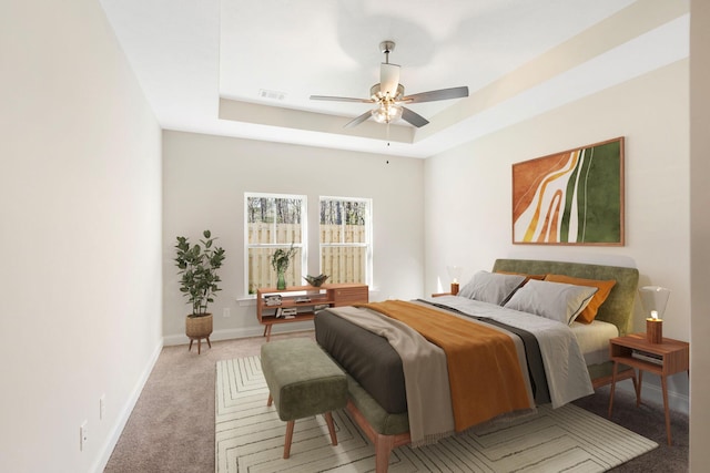 bedroom with ceiling fan, a raised ceiling, and light carpet