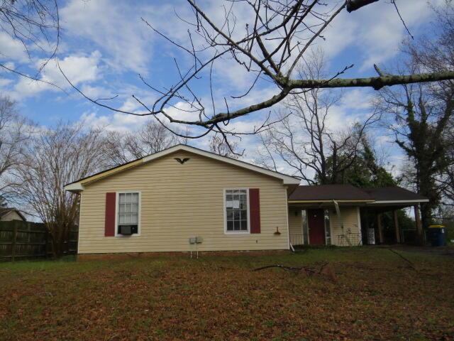 back of property with a yard, cooling unit, and fence